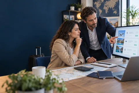 Professionnels comparant le détail du prix de plusieurs prestations de voyage sur un écran