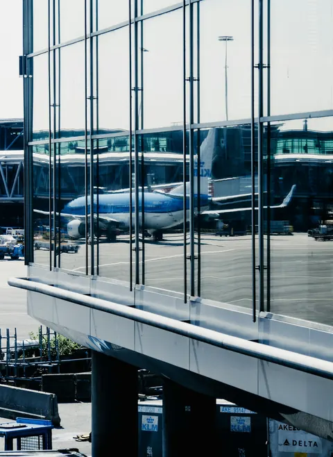 Avion et reflets vus à travers les vitres d’un terminal