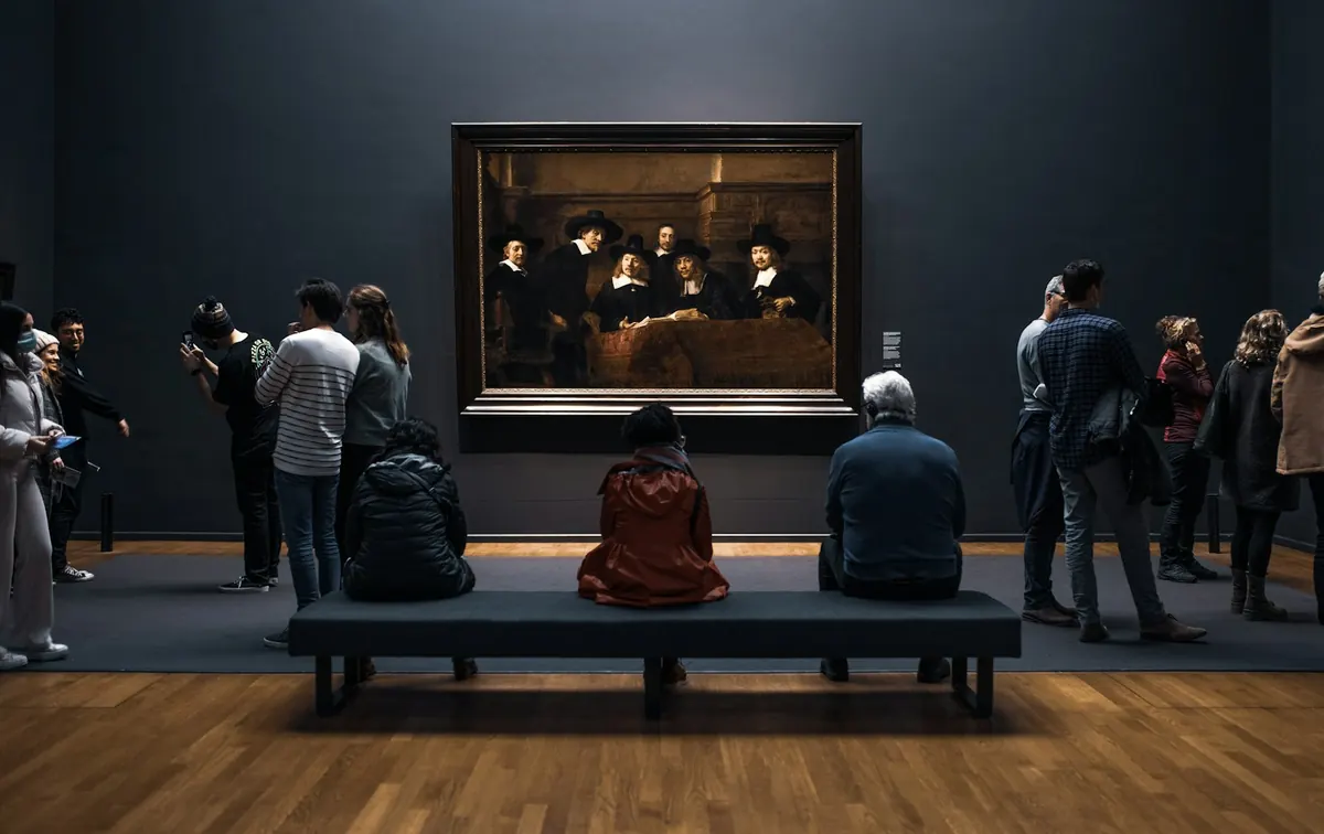 Visiteurs devant une œuvre au Rijksmuseum à Amsterdam